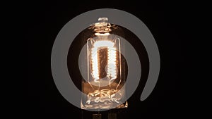 Slow motion. Flashing tungsten spiral, incandescent bulbs. Close-up. Electric vintage Edison light bulb with a spiral on