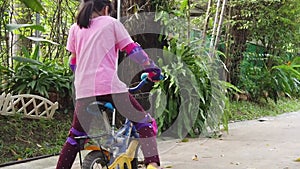 Slow motion footage of Little girl learning to ride a bicycle at home.