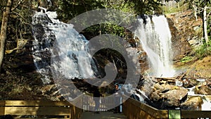 slow motion footage of the rushing waters of Smith Creek and waterfall at Anna Ruby Falls with rocks and lush green trees