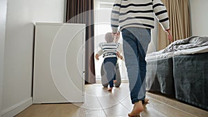 Slow motion footage of two little boys runs down a long wooden corridor towards their's mother's warm embrace.