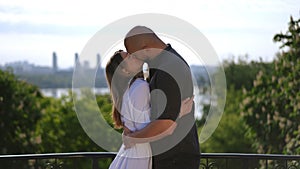 Slow motion footage of two lovers meeting. A man and a woman meet in a spring park and kiss against the backdrop of a