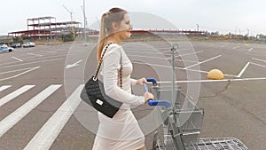 Slow motion footage of young woman walking to the supermarket on parking lot