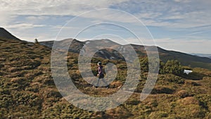 Slow motion girl hiking at sun mountain hill. Woman on grass hill run peak. People nature landscape