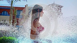 Slow motion of girl under water waterfalls to swim fountain