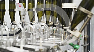 Slow-motion, glass bottles on the automatic conveyor line at the champagne or wine factory. Plant for bottling alcoholic