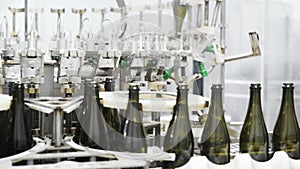 Slow-motion, glass bottles on the automatic conveyor line at the champagne or wine factory. Plant for bottling alcoholic