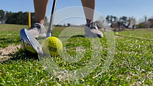 Slow motion golf club iron hitting yellow practice ball