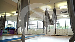 Slow motion, gray hammocks for hanging fly yoga at the gym, slidecam