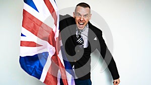 In slow motion a guy man is a fan of the United Kingdom of Great Britain Englishman on emotions holding a flag in his hands pl