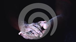 Slow motion of hands with powder splash by clapping hands. splashing hand with flour on black background.