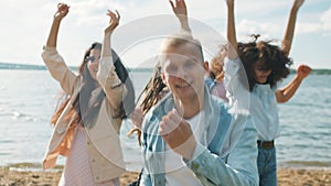 Slow motion of handsome blond man dancing with friends at open air beach party