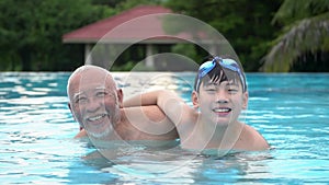 Slow motion of Happy asian family playing in pool .