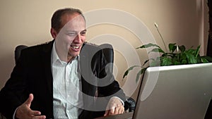 Slow motion happy businessman receives good news raising fist in a video at home