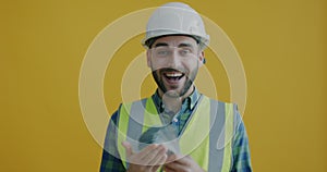 Slow motion of happy construction project manager in safety helmet and uniform counting money and laughing