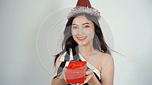 Slow-motion of happy woman with hat and holding a red christmas gift box in a gesture of giving