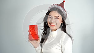Slow-motion of happy woman with hat and holding a red christmas gift box in a gesture of giving