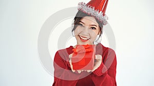 Slow-motion of happy woman with hat and holding a red christmas gift box in a gesture of giving