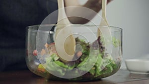 Slow motion - Health conscious young chief woman tossing a tasty organic green salad