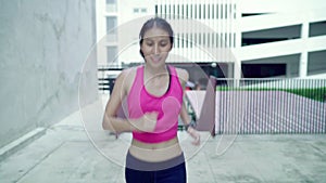 Slow motion - Healthy beautiful young Asian runner woman in sports clothing running and jogging on street in urban city.