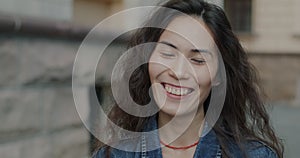 Slow motion of joyful Asian woman laughing feeling happy and excited standing in city street