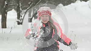 Slow motion of joyful child playing in snow. Happy girl having fun outside winter day