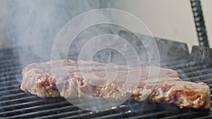 Slow motion of a large beef sirloin steak grilled on a charcoal grill