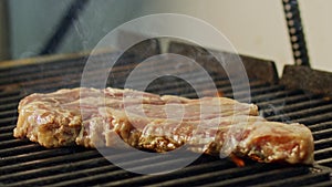 Slow motion of a large beef sirloin steak grilled on a charcoal grill