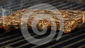 Slow motion of a large beef sirloin steak grilled on a charcoal grill