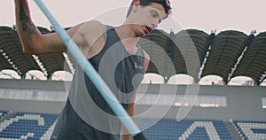 Slow motion: a Male athlete at the stadium concentrates and prepares to do a javelin throw. Attitude and serious