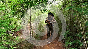 Slow-motion of man traveler with backpack walking and looking in natural forest