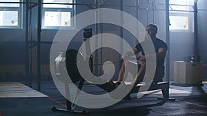 Slow motion men training rowing in gym with exercises machines and pull rope
