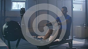 Slow motion men training rowing in gym with exercises machines and pull rope