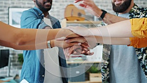 Slow motion of multi-ethnic group of people joining hands expressing unity