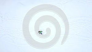 slow motion overhead view man snowboarding down by powder