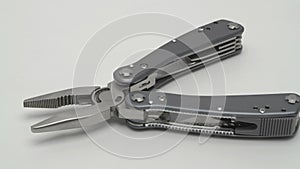 Slow motion panorama of a multitool on a white background.
