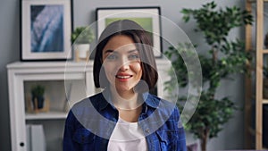 Slow motion portrait of beautiful woman in apartment smiling looking at camera