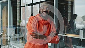 Slow motion portrait of happy African American man smiling in creative glass wall office
