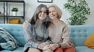 Slow motion portrait of happy family mother and teenage daughter smiling looking at camera