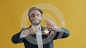 Slow motion portrait of Middle Eastern guy student dancing with bengal light enjoying party