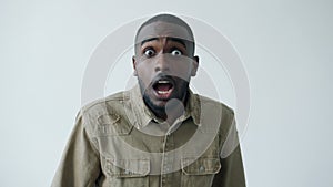 Slow motion portrait of scared African American man looking at camera with fear and shock