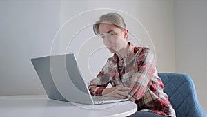 Slow motion: positive woman using laptop, having video chat with friends at home