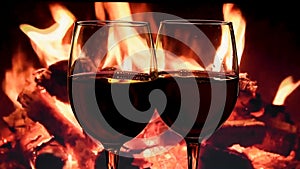 Slow motion of pouring white wine from bottle into goblet on fireplace background