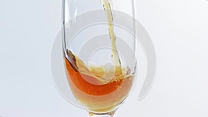 Slow motion of pouring white wine into a glass close-up on a white background