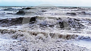 Slow motion. A powerful storm in the coastal strip. Dirty water with foam
