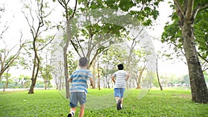 Slow motion of Preteen Asian boy running in a park