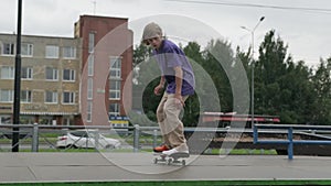Slow motion Professional skater teenager is engaged in extreme sports in skatepark doing tricks, skateboarder young