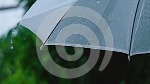 Slow Motion of raindrops falling on white umbrella