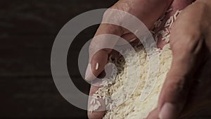 Slow motion raw rice grains falling from man`s hand