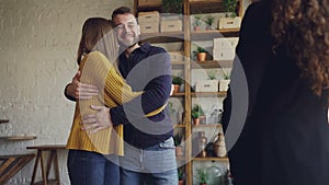 Slow motion of real estate buyers getting keys from housing agent after successful deal, kissing and hugging with
