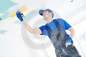 Refurbishment. Plasterer spackling a gypsum plasterboard ceiling with putty